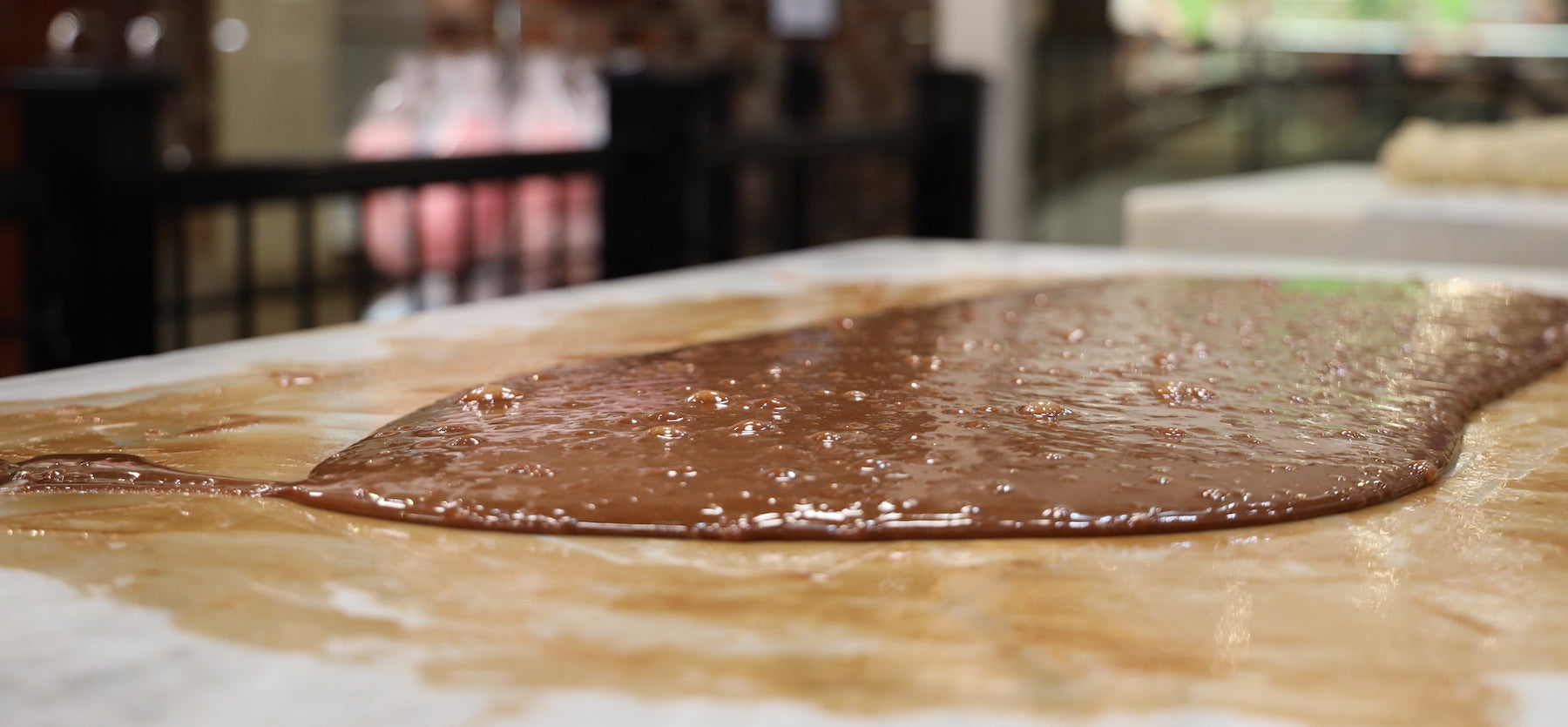 chips chocolate factory fudge in liquid form on a marble table before shaping into a loaf image